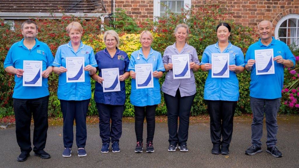 Staff at Chapel House show off their INCUS training certificates
