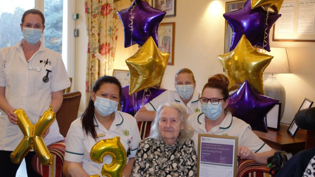 Staff and a resident at Brandon Park show off their third Outstanding