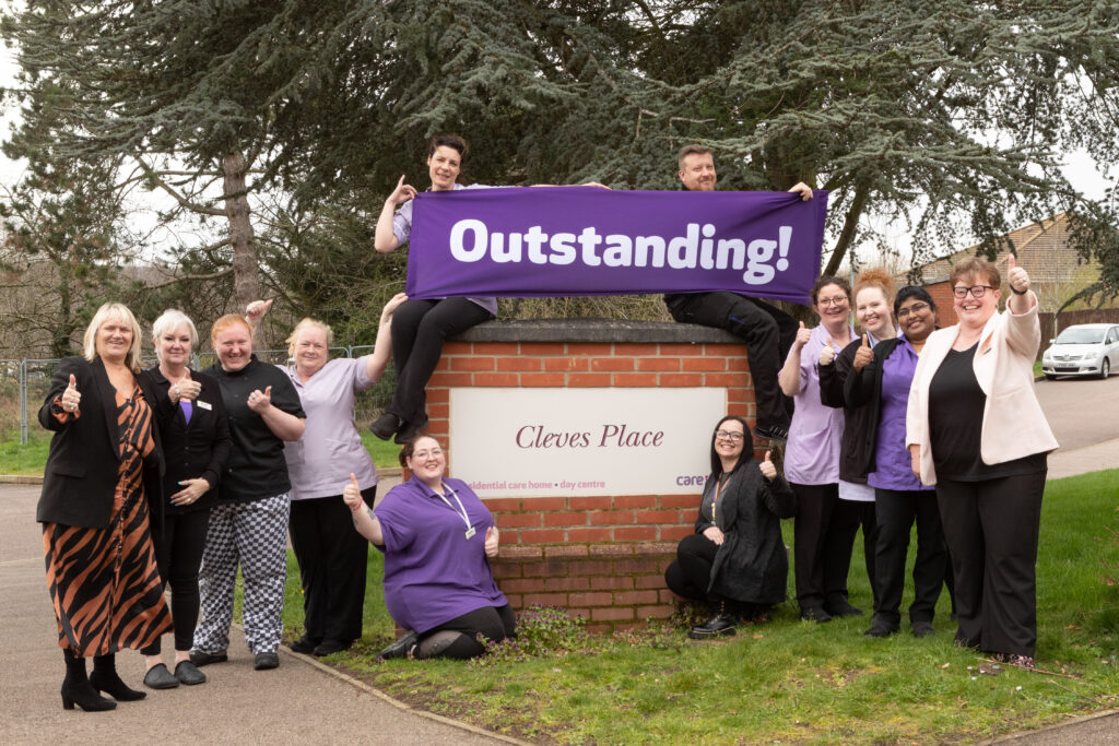 Jennie Rodgers regional director, left, Cleves Place care home manager Clare Mooney, right and staff celebrating the homes Outstanding CQC rating