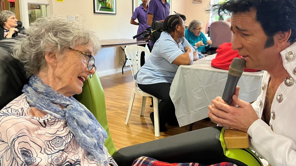 Elvis impersonator Mike Nova serenades a resident at The Close care home